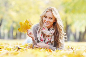 Woman lying in autumn leaves