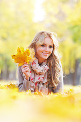 Woman lying in autumn leaves