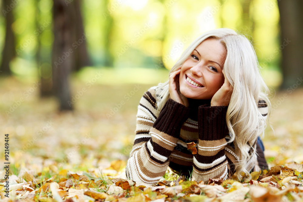 Wall mural woman on autumn leaves