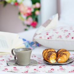 Still life with breakfast coffee, croissants and a book to read