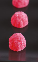 Three candy strawberry on black dish