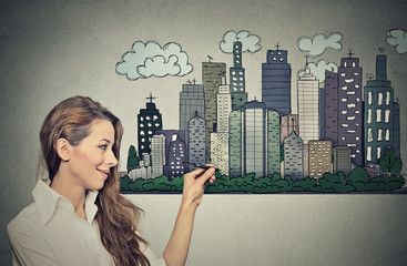 Woman drawing city skyline. Real estate development