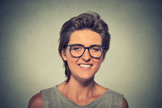 laughing young woman wearing heavy rimmed glasses looking at the camera