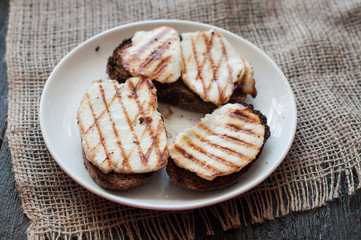 Crostini with fried cheese on the grill