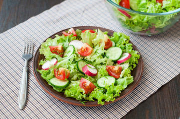 Tomato and cucumber salad with lettuce leafes