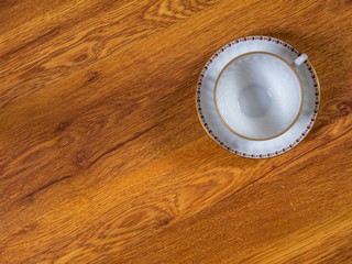Top view on the cup with saucer, standing on the wooden table