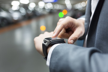 In parking car a man using his smartwatch. Close-up hands