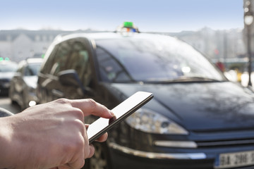 Man orders a taxi from his mobile phone. Close-up hands