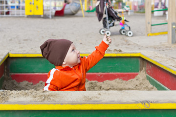 Small child is playing in sandbox