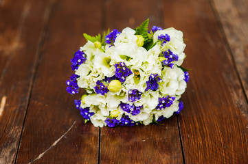 Wedding bouquet of white roses and blue flowers on the table