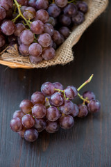 Bunch of grapes in the basket on wooden table