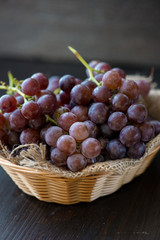 Bunch of grapes in the basket on wooden table