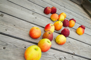 Red and yellow apples on a wooden surface