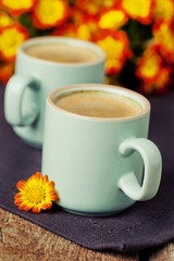 Cup of coffee with bright autumn flowers