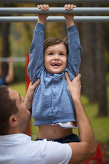 Obraz premium Happy father and son having fun in autumn parkHappy father and son having fun in autumn park