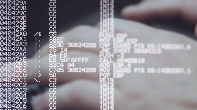 Man typing on keyboard with computer program source code in front
