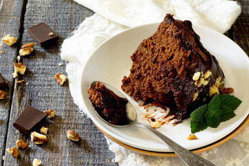 Chocolate cake with icing on a plate with a piece of