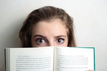 SCARED TEEN BEHIND A BOOK