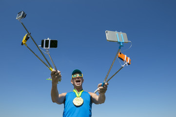 Gold medal athlete makes a face for his many gadgets on selfie sticks as he poses for a picture