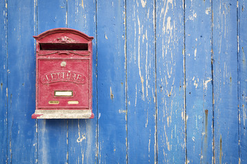 Red mailbox with blue wood background