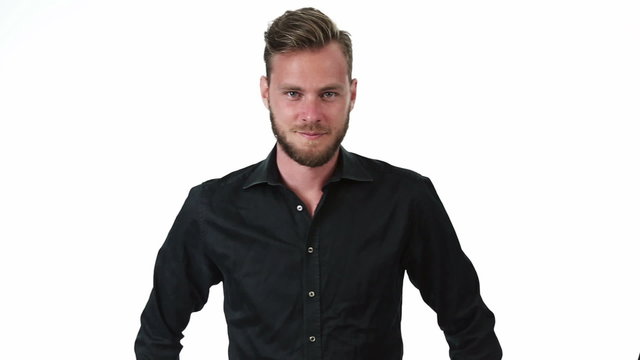 A man in his 20s wearing a black shirt standing against a white background with his hands on his hip.