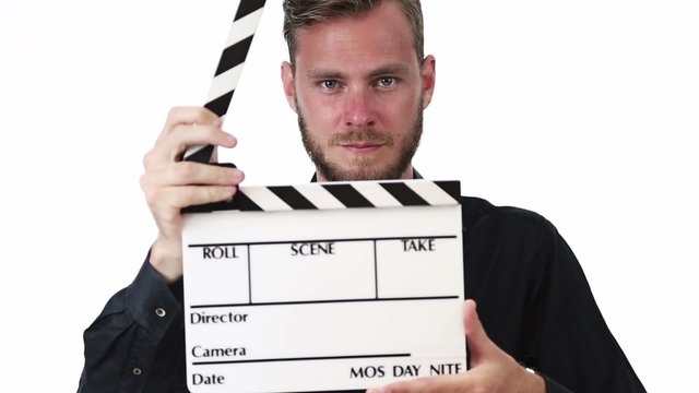 Attractive movie worker wearing a black shirt, holding a movie slate, clapping in front of camera. White background.