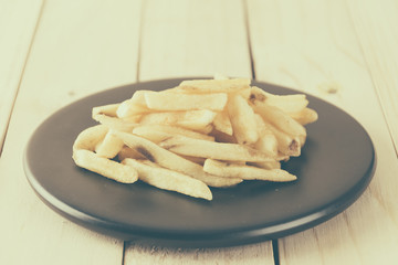 french fries on wood background - soft focus with vintage film f