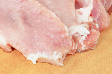 Raw meat steaks on wooden board background, DOF