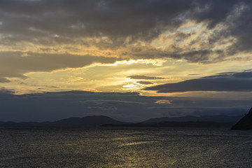 The sun sets in the clouds .