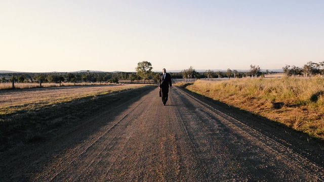 Concept: A frustrated business man is leaving the corporate lifestyle and chasing freedom in the outback of Queensland, Australia. Cinematic Portrait Style.