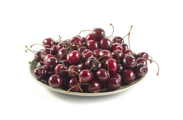 Ripe cherry on a green ceramic plate isolated on white