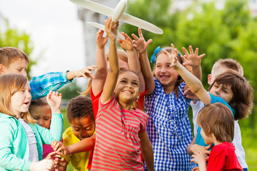 Close-up view of kids reaching after airplane toy