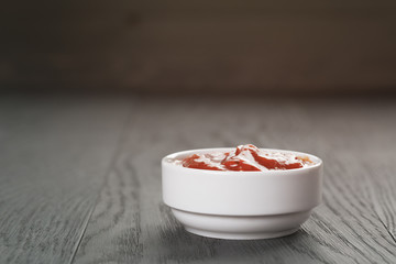 white bowl with tomato sauce on wood table
