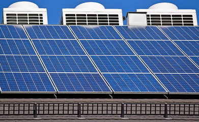 Solar panels and air condiitioners on the roof of a building