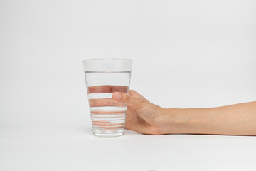 Woman hand with glass of water isolated on white background