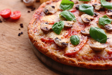 Tasty pizza with vegetables and basil on table close up