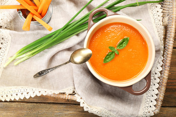 Carrot cream-soup with vegetables on table close up