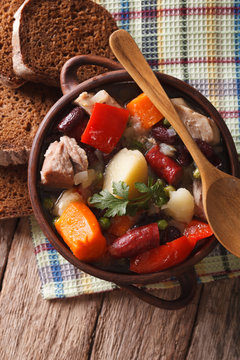 Eintopf with meat, sausages and vegetables closeup. vertical top view
