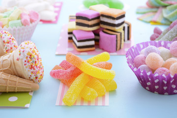 Bright Colorful Candy on Pale Bluw Wood Table.