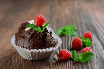 Delicious chocolate cupcake with berries on wooden table close up