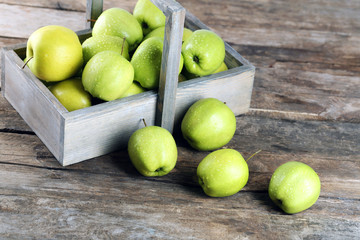 Ripe green apple in crate on wooden table close up