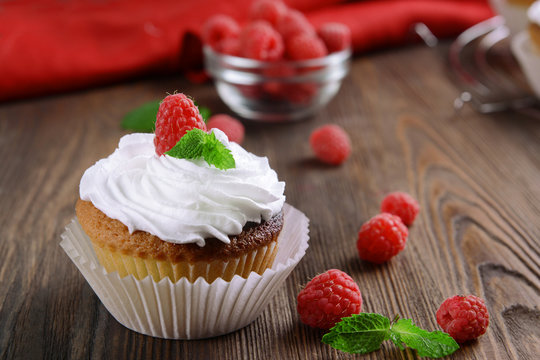 Delicious cupcake with berries and fresh mint on wooden table close up