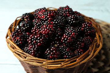Heap of sweet blackberries in basket on table close up