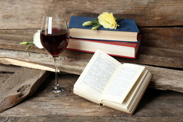 Beautiful composition with glass of wine with old books on table close up