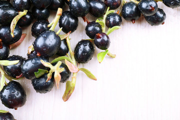 Pile of wet black currants on wooden table, closeup
