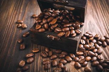Coffee beans in chest on wooden table close up