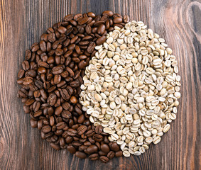 Green and brown coffee beans on wooden table close up