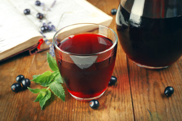 Fresh currant juice with berries and book on table close up