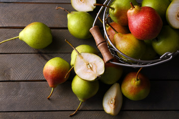 Ripe tasty pears in basket on table close up