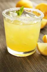 Glass of lemon juice on wooden table, closeup
